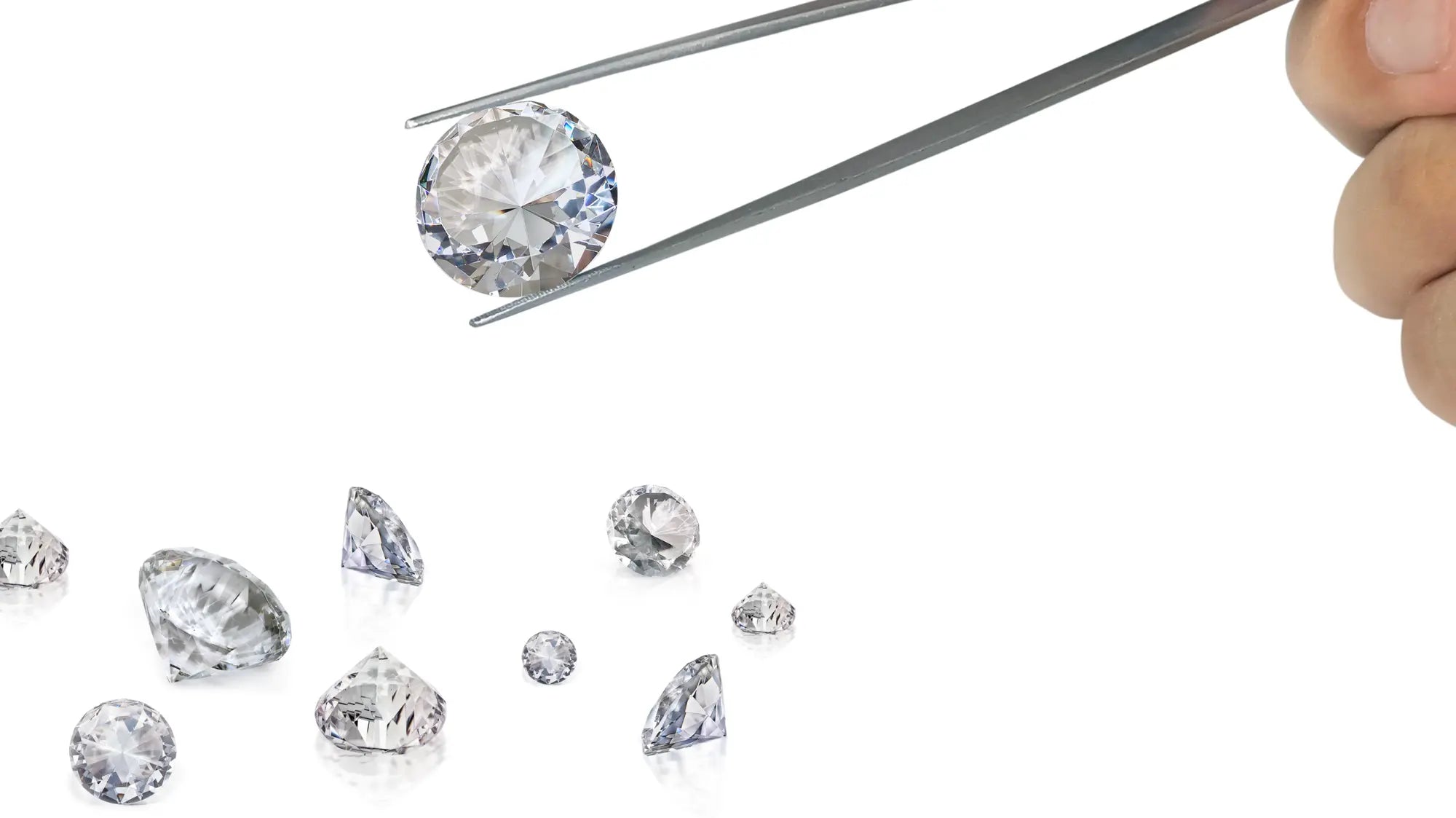 Hand hält Pinzette mit rundem, funkelndem Diamanten, weitere lose Diamanten auf weißem Hintergrund